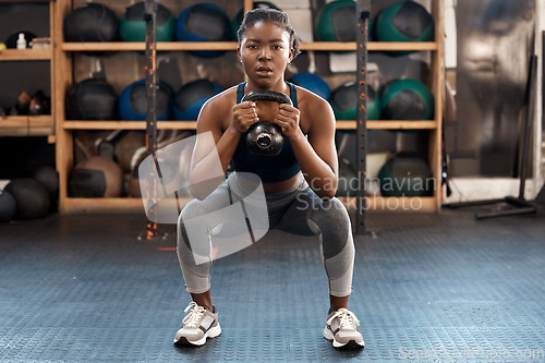 Image of Exercise, fitness and kettlebell with woman squat, workout and gym challenge with weight. African female person, strength training and wellness with sport for muscle and athlete in a health center