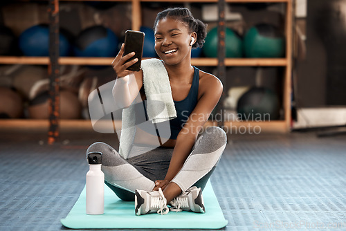 Image of Phone, selfie and black woman fitness influencer on social media on a cellphone during workout or exercise in a gym. Health, wellness and young person or athlete happy online, internet or web