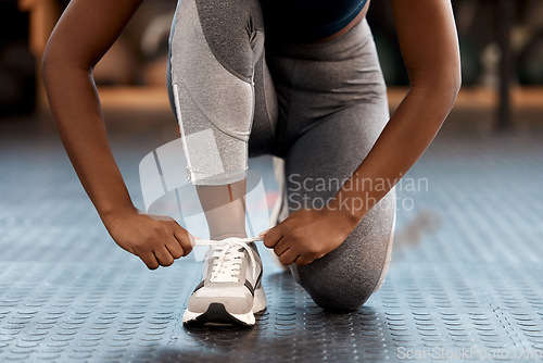 Image of Woman, hands and tying shoes in fitness at gym or running, exercise or cardio workout indoors. Hand of female person, athlete or runner tie shoe in preparation for exercising or training run on floor