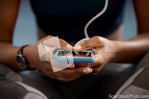 Image of Woman, hands and phone at gym in social media, networking or communication after workout exercise. Hand of female person or athlete typing, texting or chatting on mobile smartphone app in health club