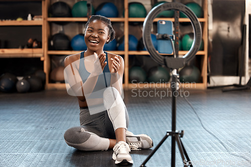 Image of Fitness, woman and phone blog for live stream exercise at gym on platform or app. Influencer, training or health vlog with black person or coach talking to social media or virtual audience with light