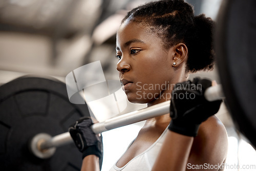 Image of Focus, weightlifting and barbell with black woman in gym for workout, strong and muscle. Health, challenge and exercise with female bodybuilder and weights for fitness, performance and commitment