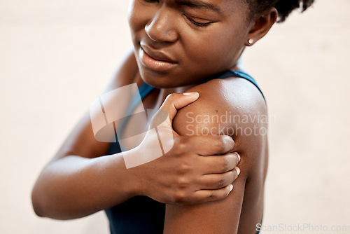 Image of Fitness, injury and black woman with shoulder pain during exercise at sports studio, massage and relief. Gym, hand on arm muscle for support and African girl with body ache during training or workout