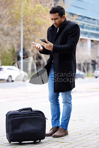Image of Frustrated businessman, phone and lost in the city with luggage for travel, commute or immigration. Upset or confused man annoyed on mobile smartphone for loss, issue or problems outside a urban town