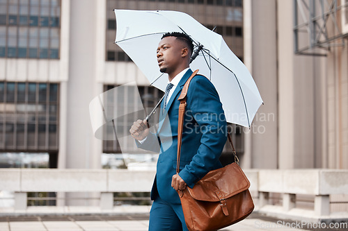 Image of Travel, business and black man with umbrella in city for weather, rain and winter season in urban town. Corporate, professional and male entrepreneur with bag for journey, commute and travelling