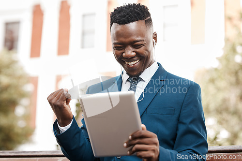 Image of Happy businessman, tablet and celebration in city for winning, promotion or good news outdoors. Black man with smile on technology for trading, profit or lottery win in success on outdoor park bench