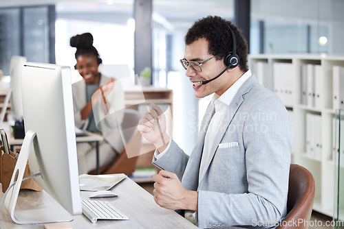 Image of Call center, man and celebrate success with headset and computer at telemarketing or customer service desk. Male agent or consultant excited for bonus, target goal or deal in crm, support or sales