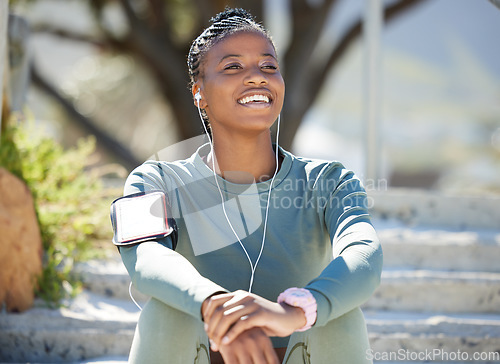 Image of Smile, fitness and black woman with on steps, music and relax with earphones, exercise and workout goal. Female person, girl and athlete listening to sound, audio and calm outdoor, sports or wellness