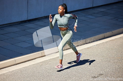Image of Running, workout and fast black woman training for a marathon, health and wellness in a city or town street. Healthy, exercise and young person, runner or athlete run with speed for fitness or energy