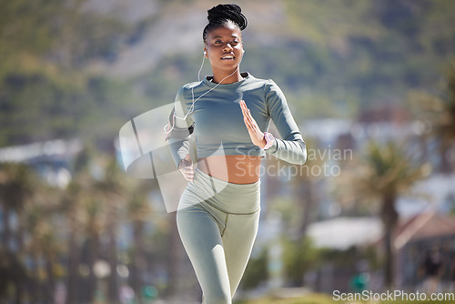 Image of Fitness, running outdoor and black woman with earphones for music, podcast or radio. Exercise, cardio and African female runner listening to audio, sound and song for workout, training and sports.