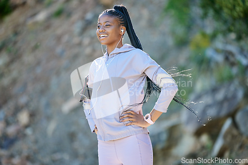 Image of Black woman hiking, fitness and earphones for music, motivation with podcast and enjoy view with smile outdoor. African female hiker, nature and mockup space with exercise and radio streaming