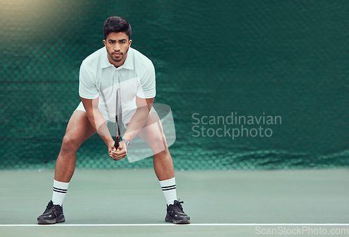 Image of Sports, space and man at court for tennis, training and mockup, mindset and focus on green background. Fitness, workout and Indian male player with racket for match, competition and body exercise