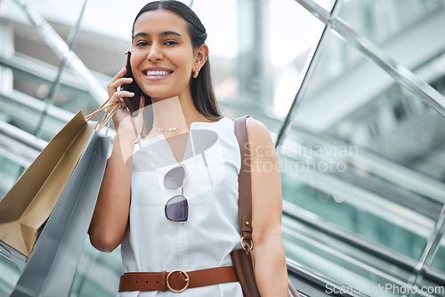 Image of Phone call, escalator and a woman with a shopping bag in mall for fashion, sale or discount deal. Portrait of female person or happy customer talking on smartphone for retail promotion conversation