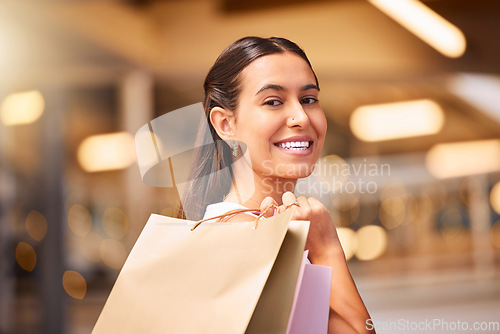 Image of Face, smile and a woman with a shopping bag in a mall for fashion, sale or discount deal. Female person or happy customer portrait with retail bags for luxury promotion, commerce and product offer