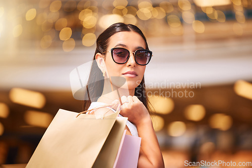 Image of Face, sunglasses and a woman with a shopping bag in mall for fashion, sale or discount. Portrait of serious and rich customer person with retail bags for product promotion, commerce and luxury offer