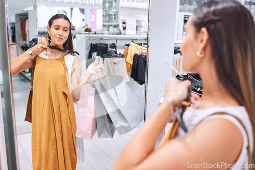 Image of Shopping, fashion and a woman in boutique mirror at mall for clothes sale or discount deal. Female person or happy customer in retail store with a paper bag, luxury brand and style choice or decision