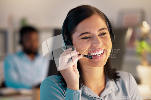 Image of Call center, smile and business woman in office for customer service, telemarketing or support at night. Contact us, crm and female sales agent, consultant or employee working on consulting deadline.