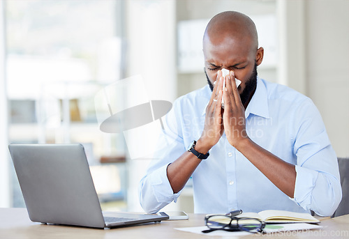 Image of Black man in office, blowing nose with allergies and sick while at work, professional person with virus and health problem. Businessman at desk with allergy, using tissue with disease and illness