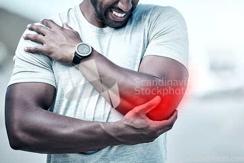 Image of Fitness, elbow and injury with a sports man holding his joint in pain while outdoor for a workout. Exercise, anatomy and accident with a male athlete feeling tender while training for recreation