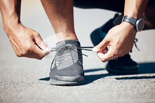 Image of Man, hands and tie shoes on road for fitness, running exercise or cardio workout outdoors. Hand of male person, athlete or runner tying shoe getting ready for exercising or training on asphalt street