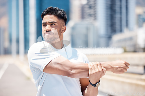 Image of Man, fitness and stretching arms in city for running, cardio workout or exercise in the outdoors. Fit, active or sporty male person, athlete or runner in warm up arm stretch before training in town