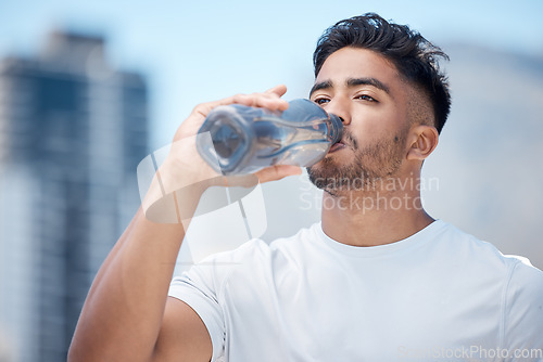 Image of Man, fitness and drinking water in city workout, cardio exercise or running for sustainability outdoors. Thirsty male person, athlete or runner with drink for hydration, rest or break in urban town