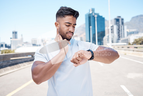 Image of Fitness, man and watch in city for pulse, heart rate or checking performance after workout or exercise. Fit, active and sporty male person, athlete or runner looking at wristwatch for cardio health