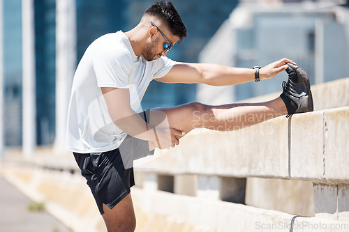 Image of Stretching, running and legs with man in city for cardio, marathon and performance. Workout, exercise and health with male runner and body warm up in road for training, sports and competition