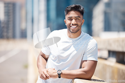 Image of Fitness, man and portrait in the city with break from running, workout and exercise outdoor. Urban, male person and Indian athlete with happiness, wellness and health from run for race in town