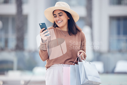 Image of Shopping, phone and Indian woman in city with bag online for bargain notification, social media and internet. Retail, fashion and female person on smartphone for chat, mobile app and website sale