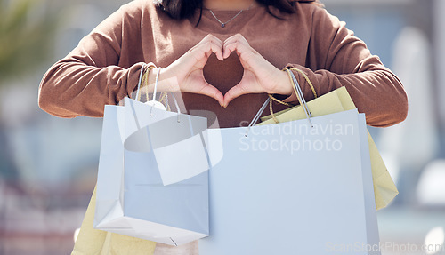 Image of Heart hands, person and shopping bags from fashion clothing discount, deal and sale. City, woman and emoji hand sign with love for retail purchase, style payment and boutique in town at mall