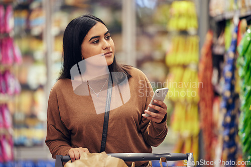 Image of Grocery, shopping and phone with woman in supermarket for choice, research and cooking app. Product, retail and groceries sale with female customer in store for nutrition, offer and food cost