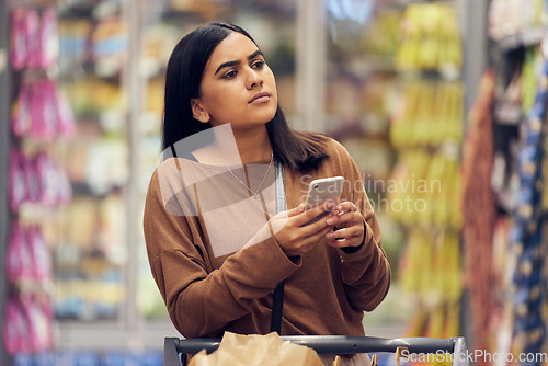 Image of Choice, shopping and phone with woman in supermarket for grocery, research and cooking app. Product, retail and groceries sale with female customer in store for nutrition, offer and food cost