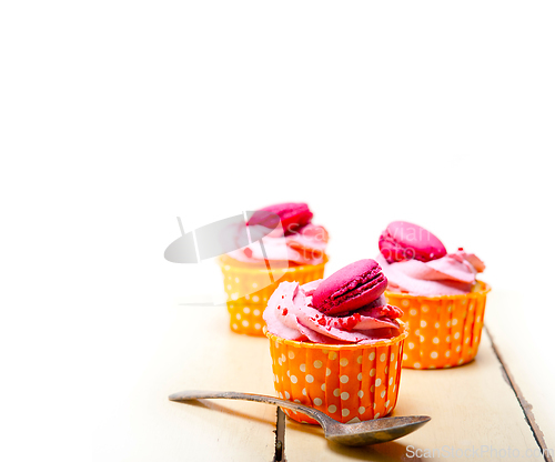 Image of pink berry cream cupcake with macaroon on top