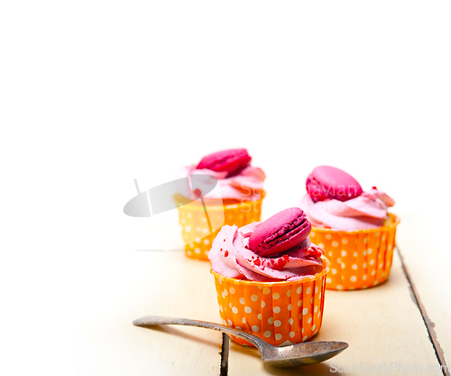 Image of pink berry cream cupcake with macaroon on top