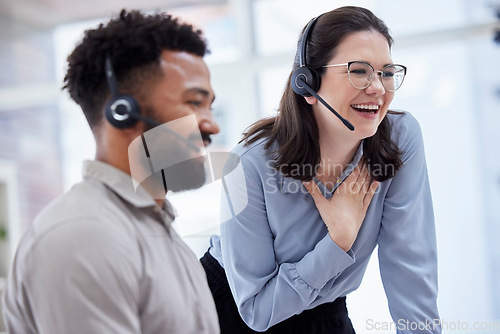 Image of Cheerful caucasian call centre telemarketing agent training new mixed race assistant on in an office. happy supervisor troub