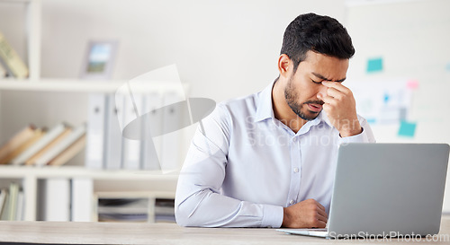 Image of Mental health, man with a headache and burnout with laptop at his desk at a modern workplace office. Stress or tired, mistake or fatigue problem and male person sad or depressed at his workstation