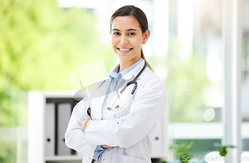 Image of Portrait, healthcare and arms crossed with a doctor woman in the hospital for insurance or treatment. Medical, happy or smile with a young female medicine professional standing alone in a clinic