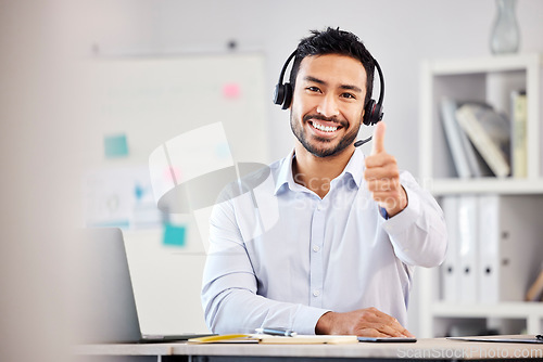 Image of Call center, portrait or happy man with thumbs up for agreement in customer services help desk. Smile, thumb up or Asian sales agent with like, success or yes hand sign in telecom for CRM success