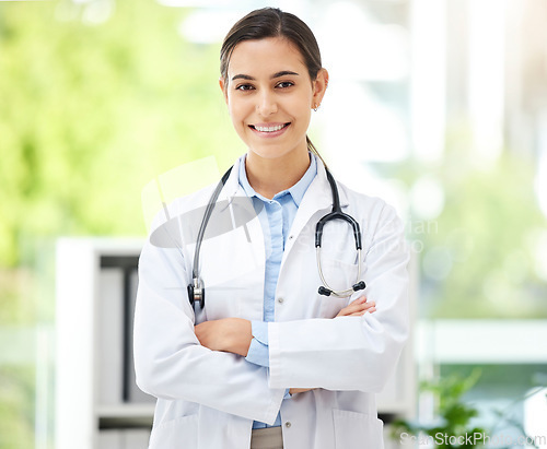 Image of Portrait, medical and arms crossed with a doctor woman in the hospital for insurance or treatment. Healthcare, happy or smile with a young female medicine professional standing alone in a clinic