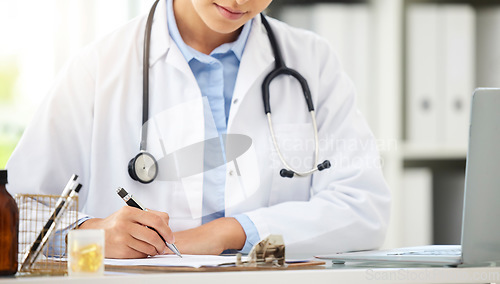 Image of Planning, doctor writing on a clipboard and with laptop at a desk in a modern office with lens flare. Healthcare, medical research and female nurse or surgeon with stethoscope write notes at work