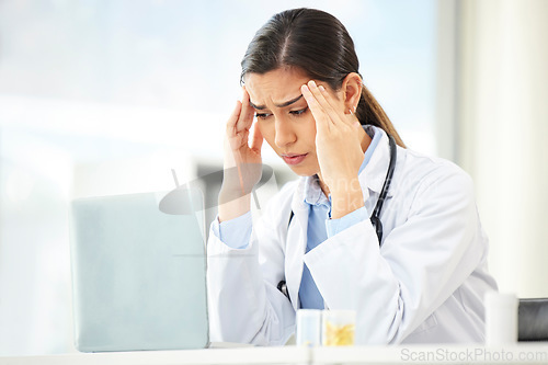 Image of Mental health, woman doctor with headache and laptop at her desk in a modern office. Anxiety or stress, depression or mistake and sad female surgeon or nurse at her workstation with problem at work