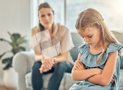 Image of Angry mom, sad child and discipline in living room, frustration and problem with naughty girl behaviour in home. Scolding, punishment and frustrated mother, stubborn kid and communication with anger.