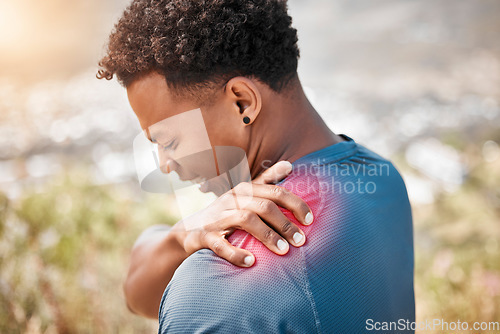 Image of Fitness, shoulder pain and injury with a sports man outdoor in nature for cardio or endurance running. Exercise, medical emergency or accident with a young male athlete holding a joint while training