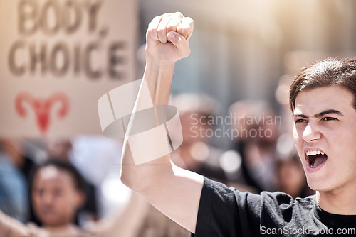 Image of Protest, rally and man with fist raised for freedom, human rights or equality outdoor in city. Speaker with community people hands, poster or sign to shout for politics, change or reproductive choice