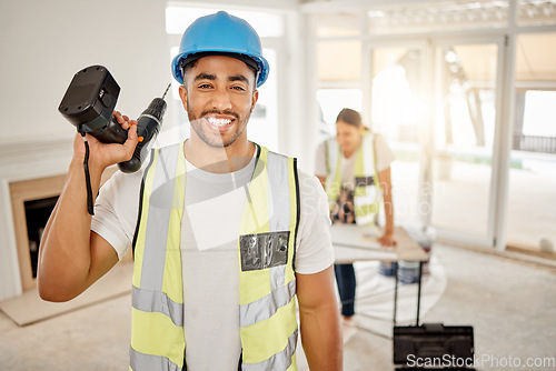 Image of Portrait of man, construction and home renovation with drill, helmet and working mindset in apartment. Yes, smile and diy renovations, happy handyman in safety and building project tools in new house