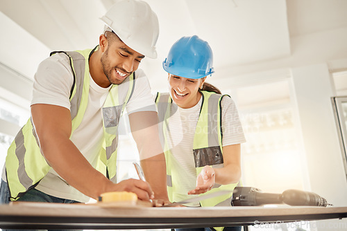 Image of Engineer, construction and team working at table for maintenance, architecture or carpentry. Man and woman talking, laughing and writing or measuring with handyman tools for teamwork and planning