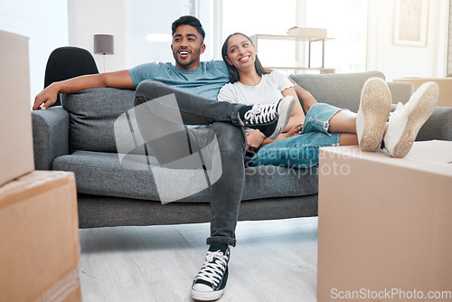 Image of Homeowners, relax and couple on a sofa, boxes and real estate with property, living room and moving in. Relationship, woman and man on a couch, love and mortgage with happiness, marriage or cardboard