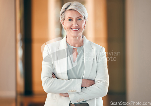 Image of Portrait, smile and arms crossed with a senior business woman in her corporate workplace. Happy, vision and leadership with a happy mature female manager standing in her office wearing a power suit