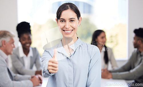 Image of Portrait, smile and a business woman thumbs up in the boardroom with her team planning in the background. Leadership, workshop and support with a happy young female employee standing in the office